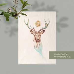 A4 wooden wall art showing a stag's head with moon between it's antlers. The image has been burned into wood and highlighted with turquoise and gold.